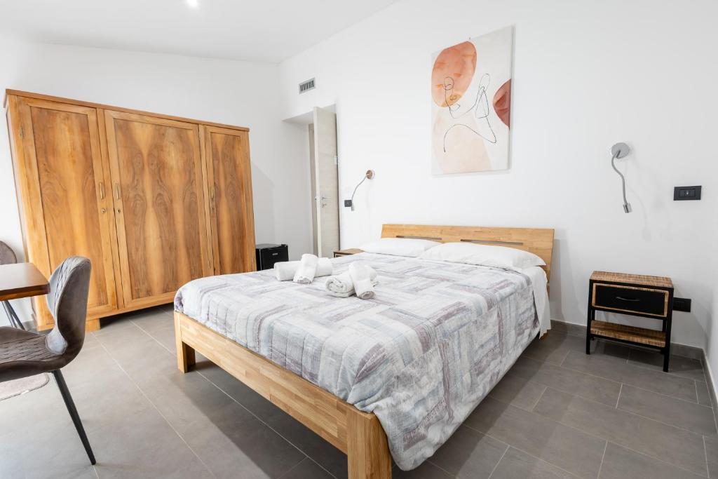 阿尔盖罗MaBi的一间卧室配有一张床和一个木制橱柜