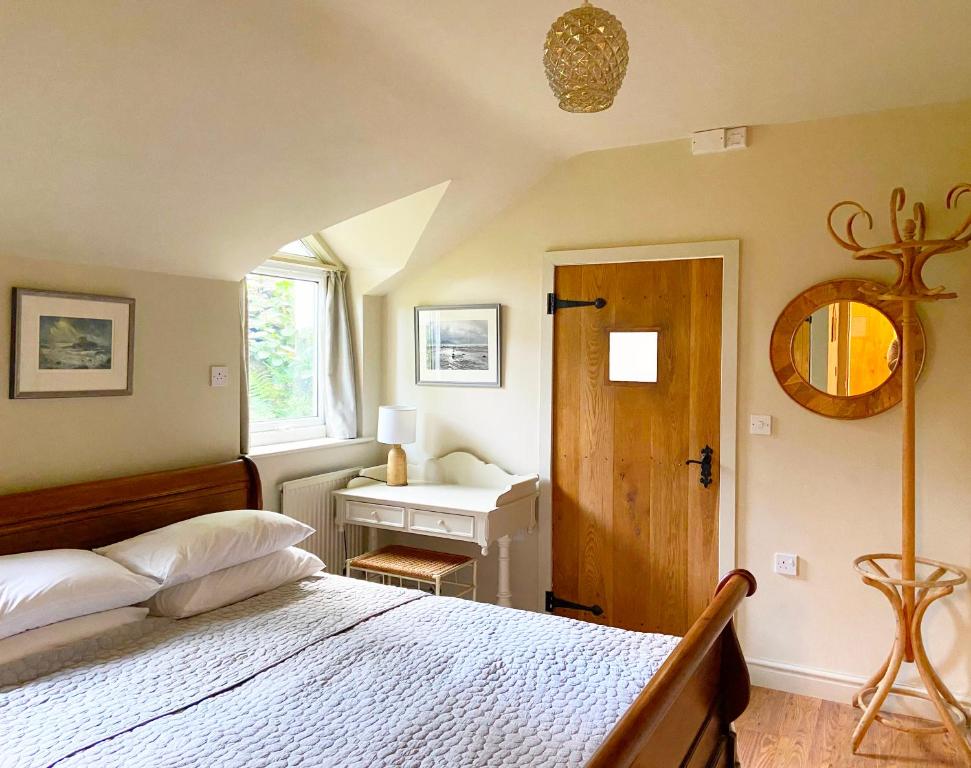 卡纳芬Close to Snowdon with Mountain views of Snowdonia的一间卧室配有一张床、一个窗口和一张书桌