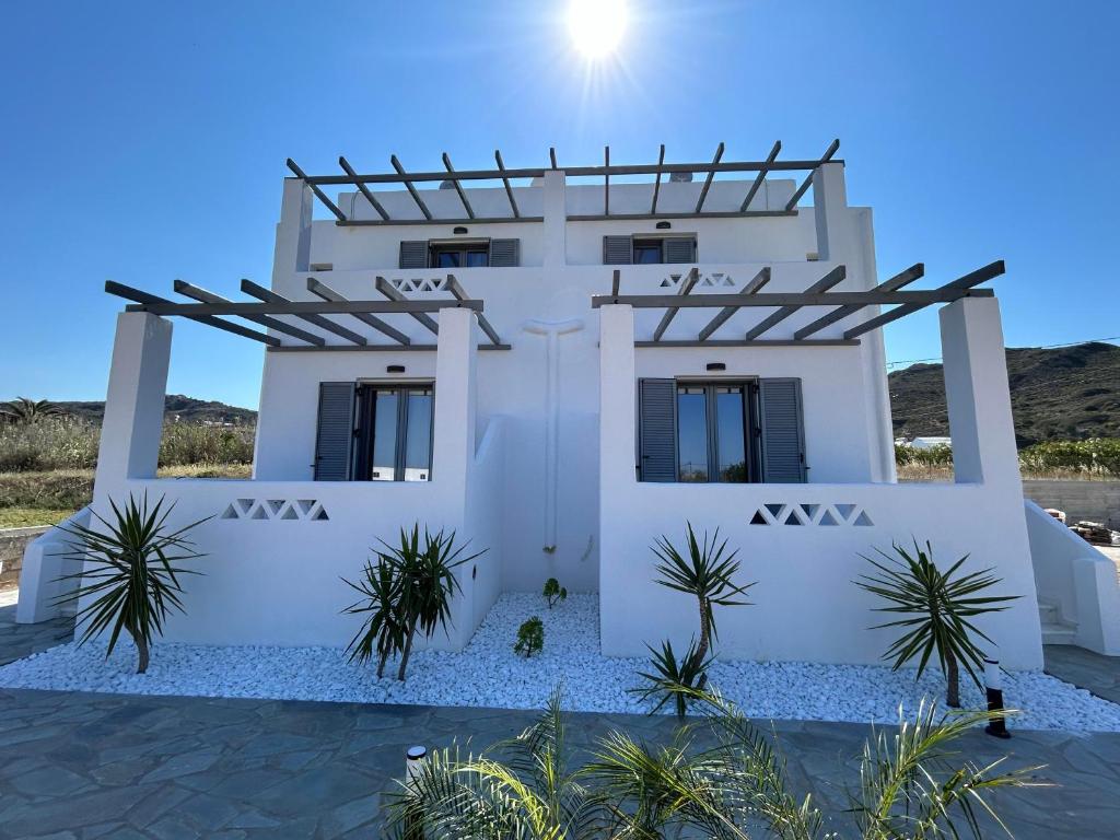斯基罗斯岛Filia Skyros Suites的一座棕榈树掩映的白色房子