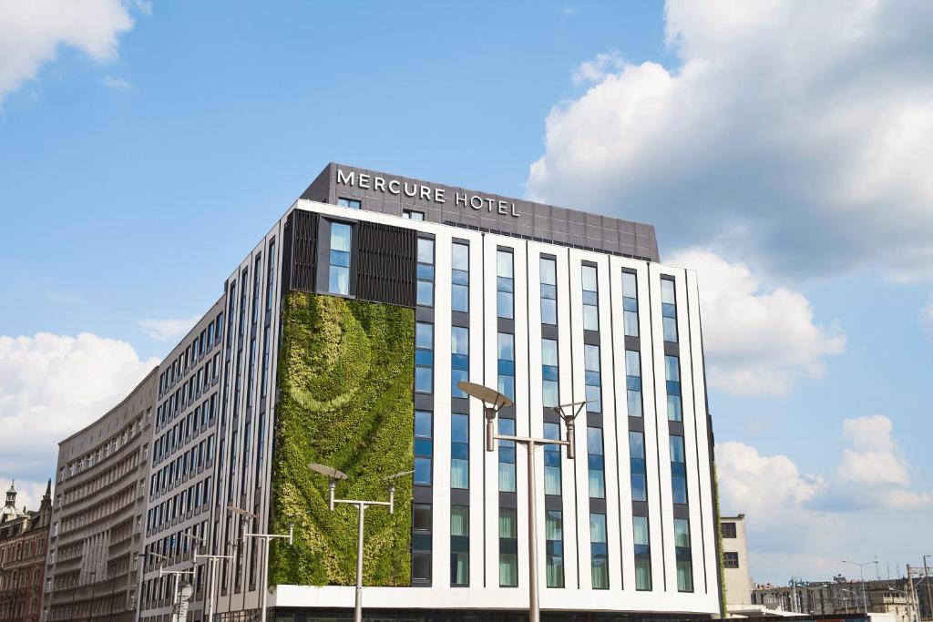 卡托维兹Mercure Katowice Centrum的一座建筑的侧面有植物