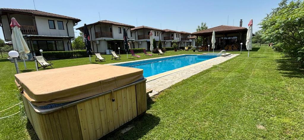 帕维尔巴尼亚Bendida Village的后院设有游泳池和部分房屋