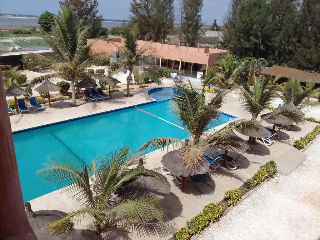 达喀尔Hôtel Entre Lac et Mer的棕榈树度假村泳池的空中景致