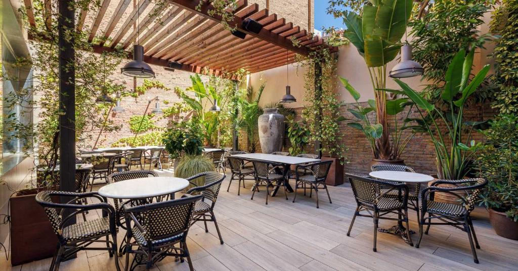 巴塞罗那隆达雷赛布酒店的户外庭院设有桌椅和植物