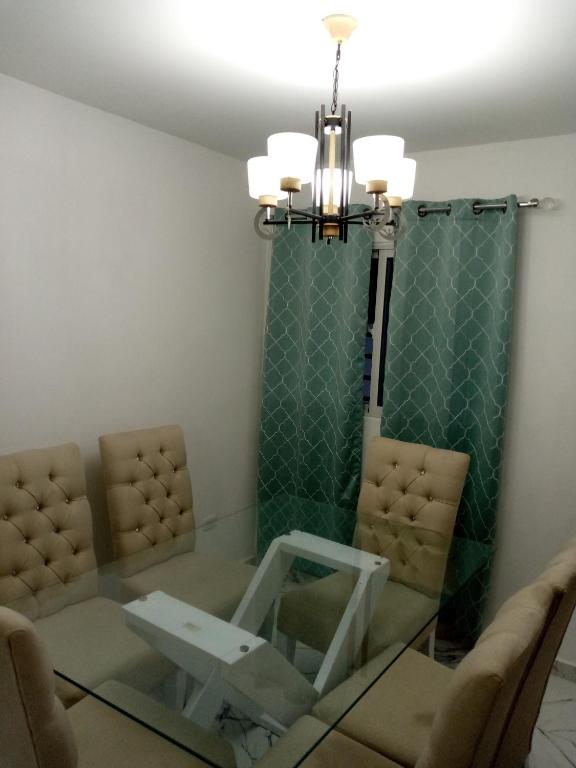 LiceyApartamento Amublado con piscina的一间带玻璃桌和吊灯的用餐室