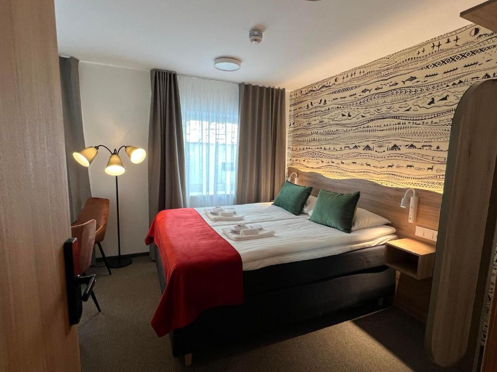 霍宁斯沃格Arctic Hotel Nordkapp的酒店客房,配有一张带红色毯子的床
