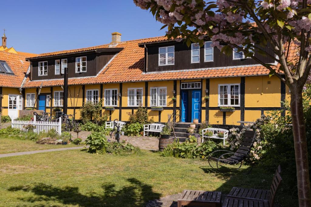 阿灵厄斯莱格特斯伽登潘森酒店的蓝色门和院子的黄色房子