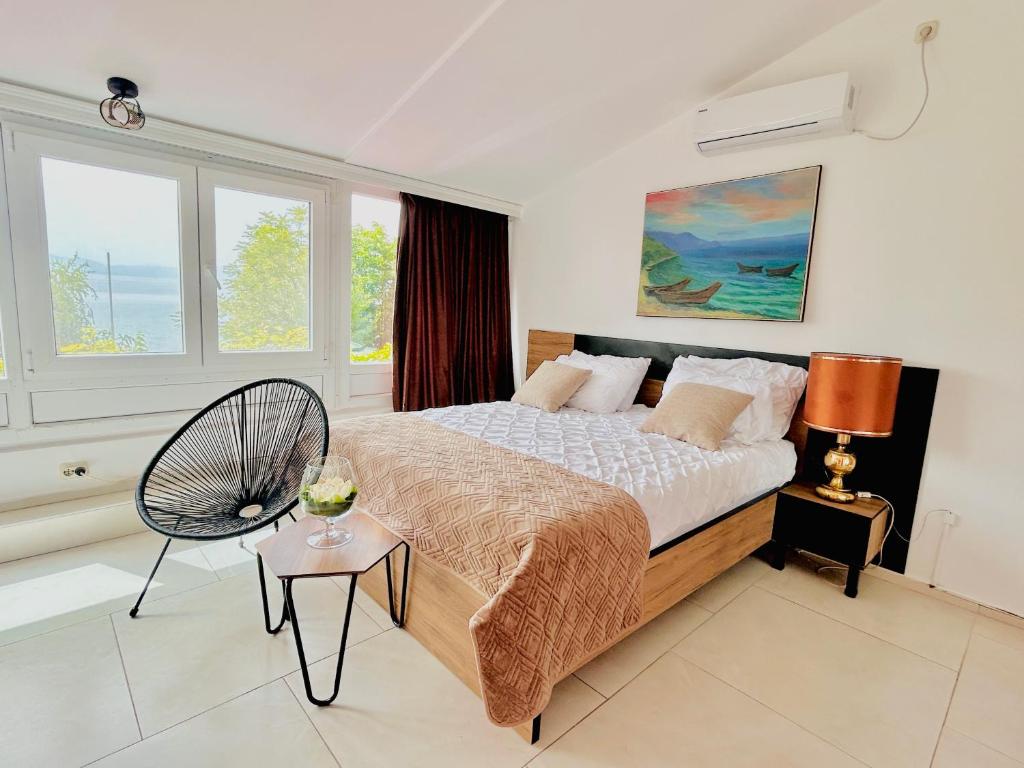 奥赫里德拉贾丁酒店的一间卧室配有一张床、一把椅子和窗户。