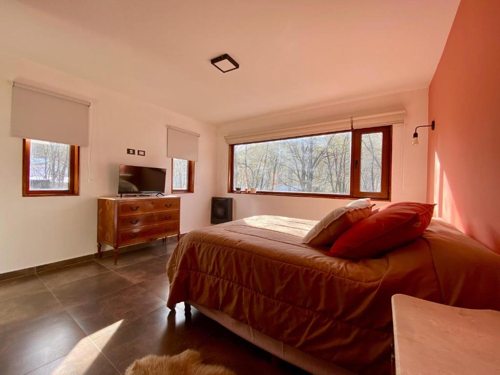 乌斯怀亚Bosques de ñires的一间卧室设有一张床和一个大窗户