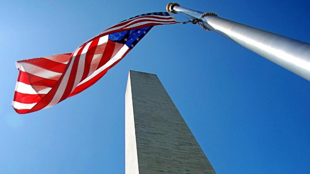 费尔法克斯费尔法克斯阿灵顿大道快捷假日酒店的挂在洗涤顿纪念碑旁的美国国旗