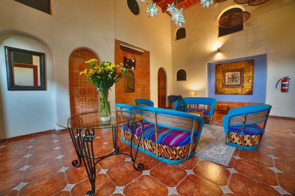 圣路易斯波托西Hotel Casa Tequis San Luis Potosi的一间设有玻璃桌和蓝色椅子的用餐室