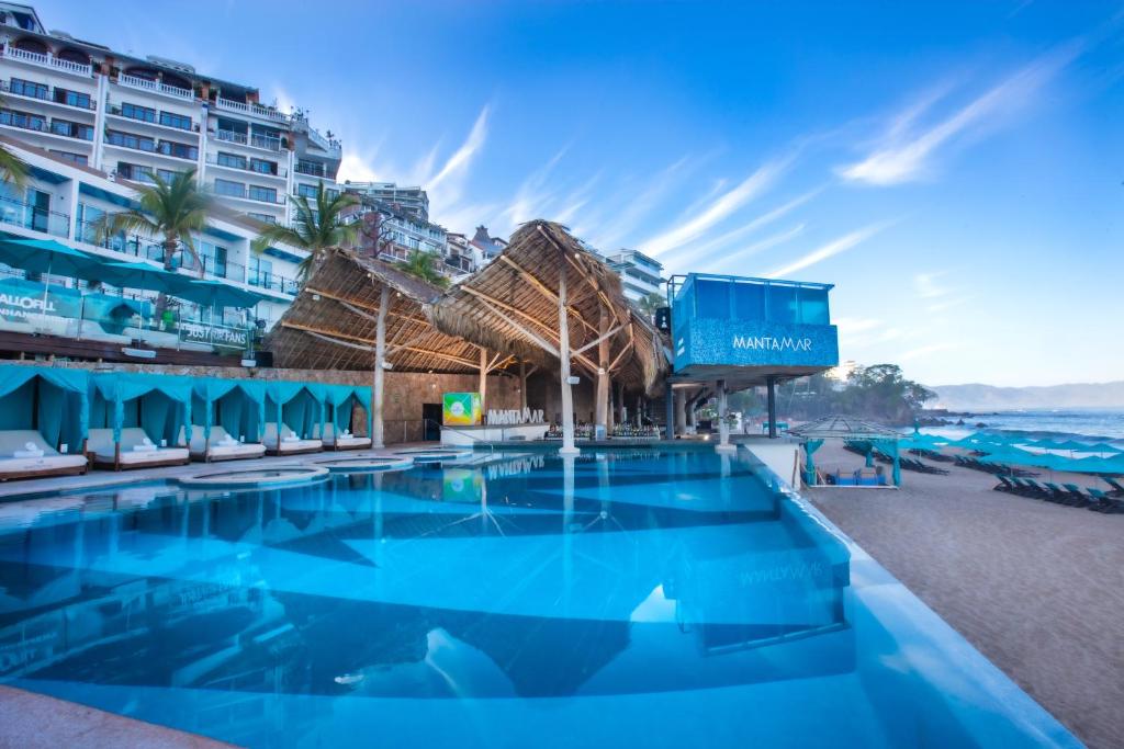 巴亚尔塔港阿尔玛豪华度假村 - LGBT海滩体验的海滩上的游泳池,酒店背景