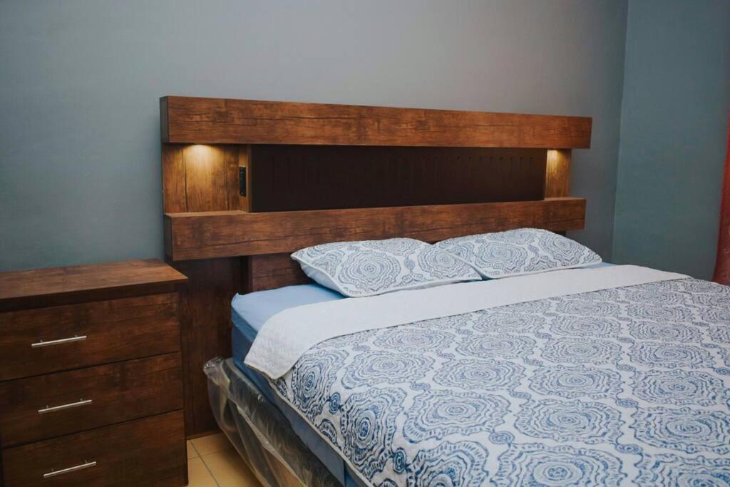 圣米格尔Encantadora Casa de Residencial的一间卧室配有一张带木制床头板的床