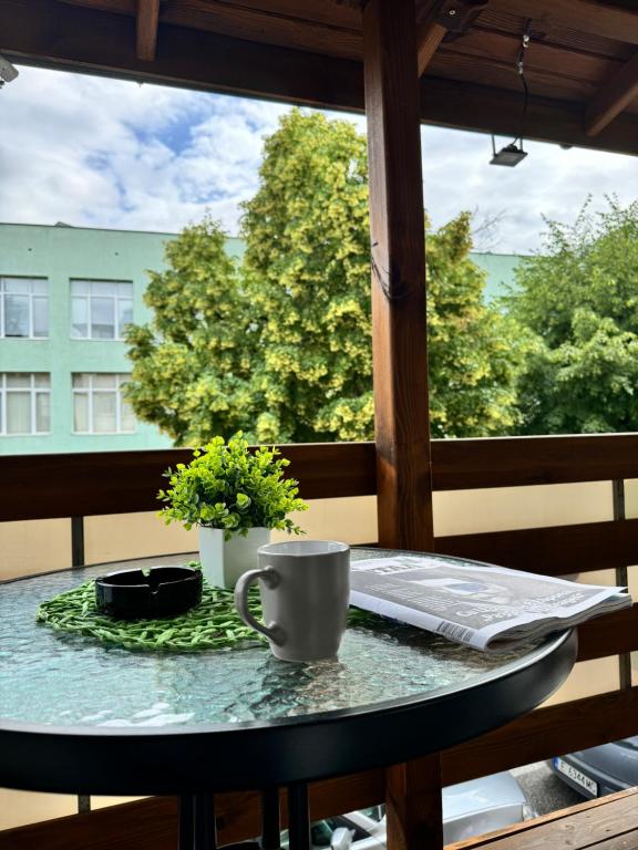 桑丹斯基Apartment Alex的阳台上的桌子和咖啡杯