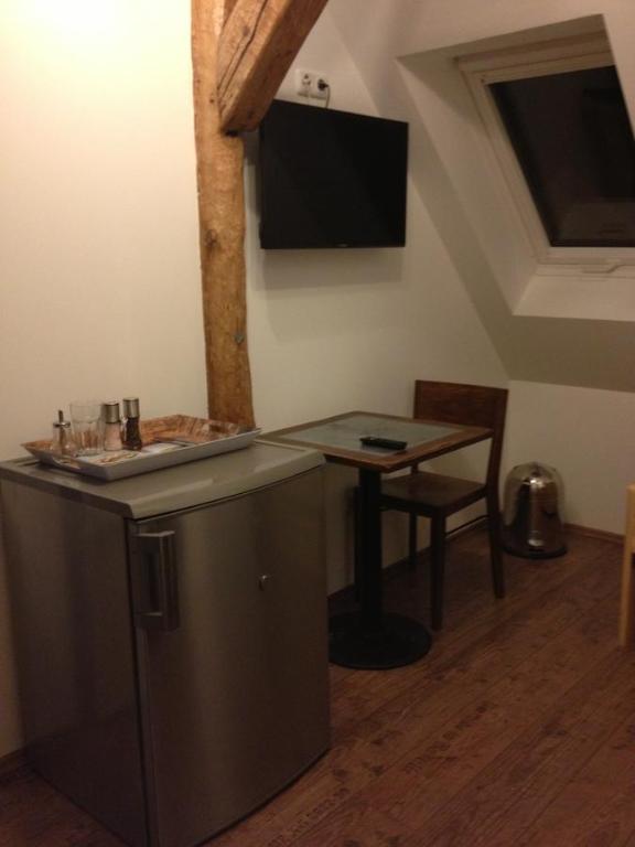 埃朗根埃朗根老城区酒店的厨房配有桌子,墙上设有电视