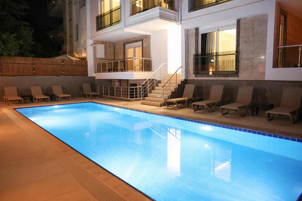 安塔利亚Livia Luxury Apart Hotel的一座带椅子的游泳池以及一座建筑