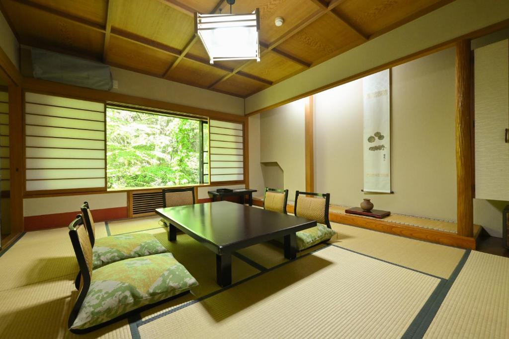 草津Osakaya Ryokan的客房设有桌椅和窗户。