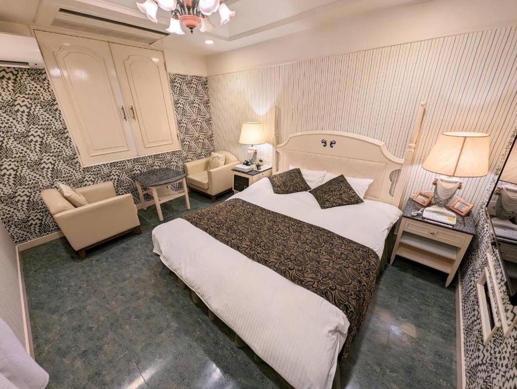 奈良D-CUBE奈良店的酒店客房带一张大床和一把椅子