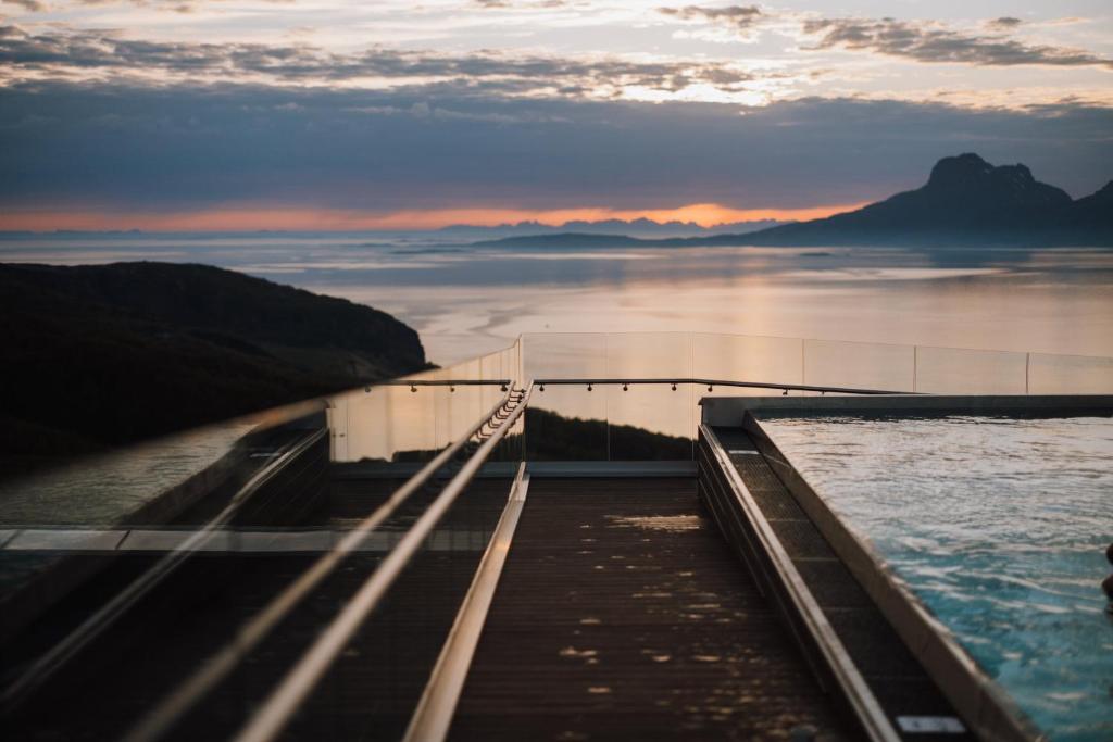 波多Wood Hotel Bodø的日落时分水面上的桥梁
