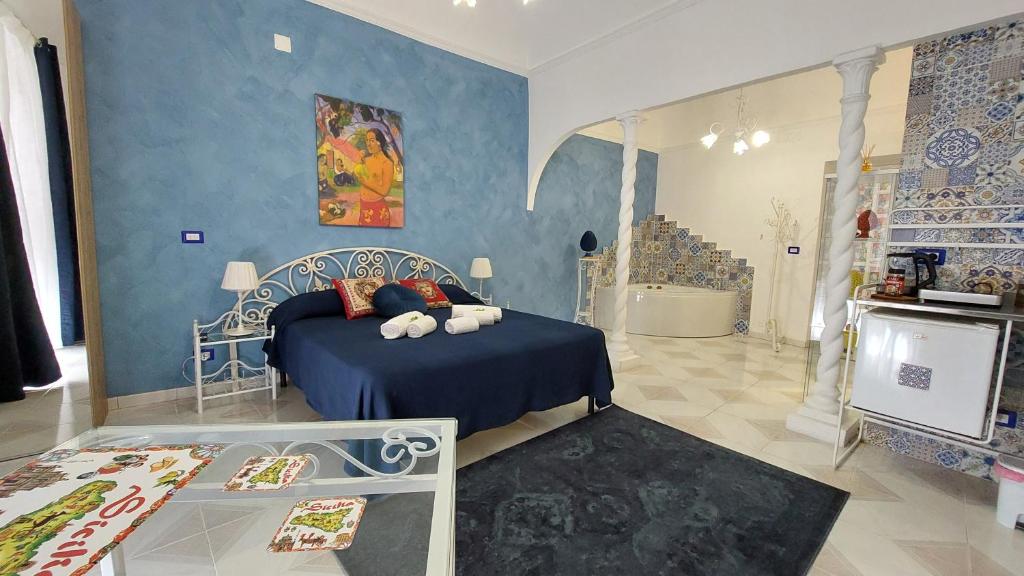 卡塔尼亚GL Golden City Apartments的一间卧室设有一张床和蓝色的墙壁