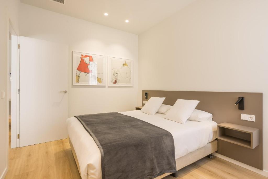 瓦伦西亚Mon Suites Jardín de Ayora的白色卧室配有一张带白色枕头的大床