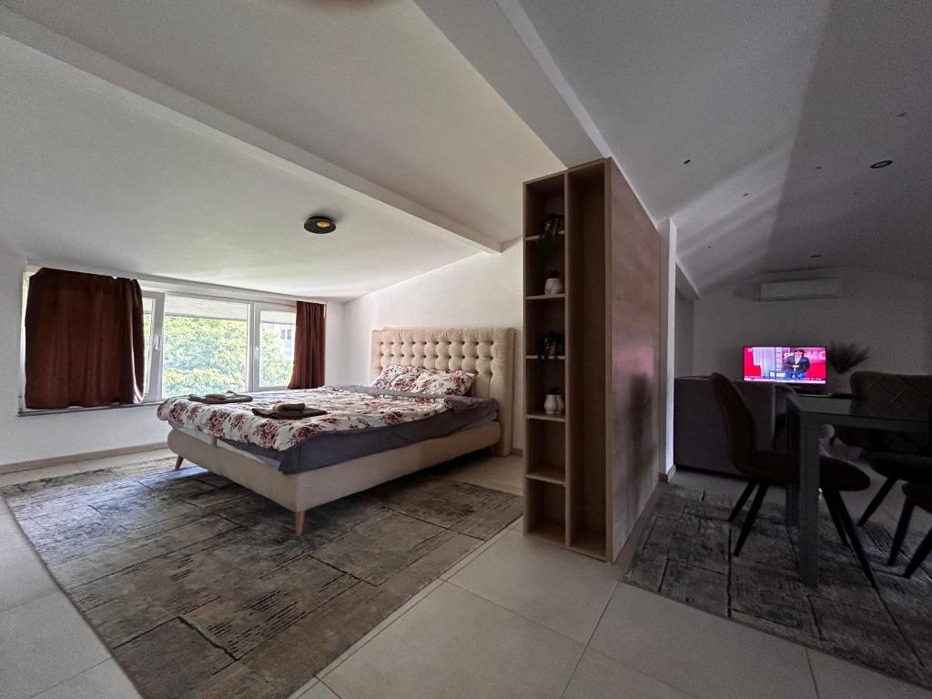 科查尼Anton Lux Apartment的一间卧室配有一张床、一张桌子和一个窗户。