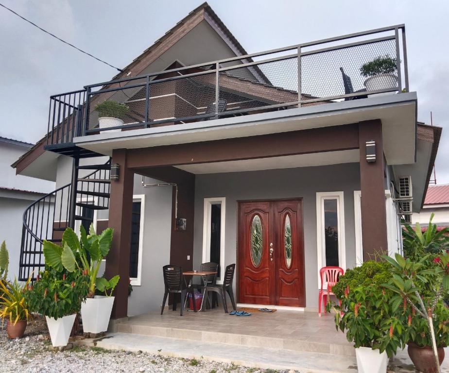 珍南海滩Villa Adeeva Homestay Langkawi的带阳台和木门的房子