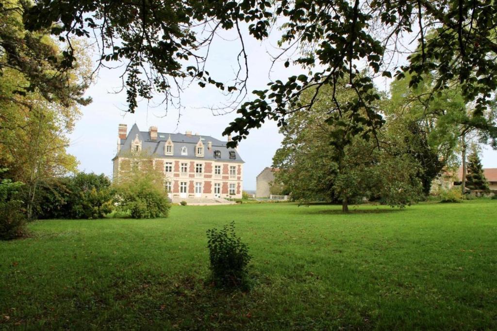 Château du Mont de Guny的绿色田野中间的大房子