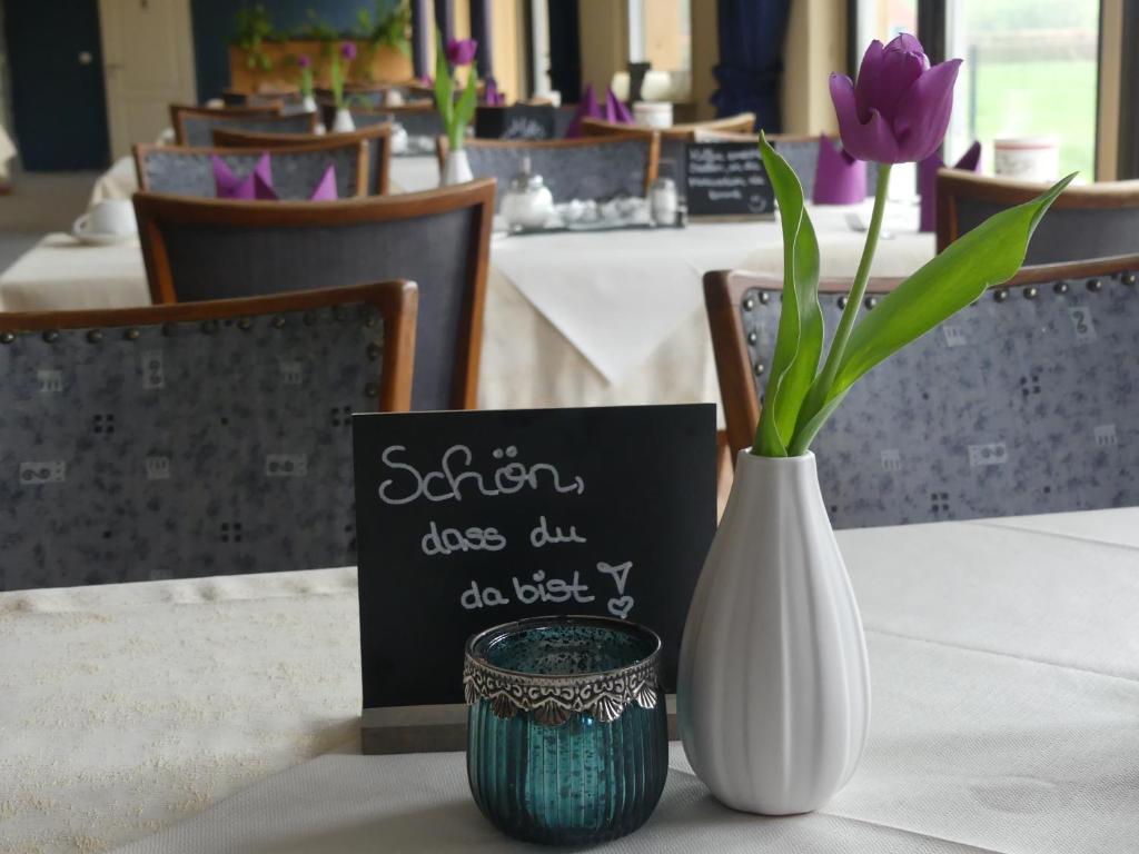 奥利希斐科特宾馆的白色花瓶,桌上有一朵紫色花