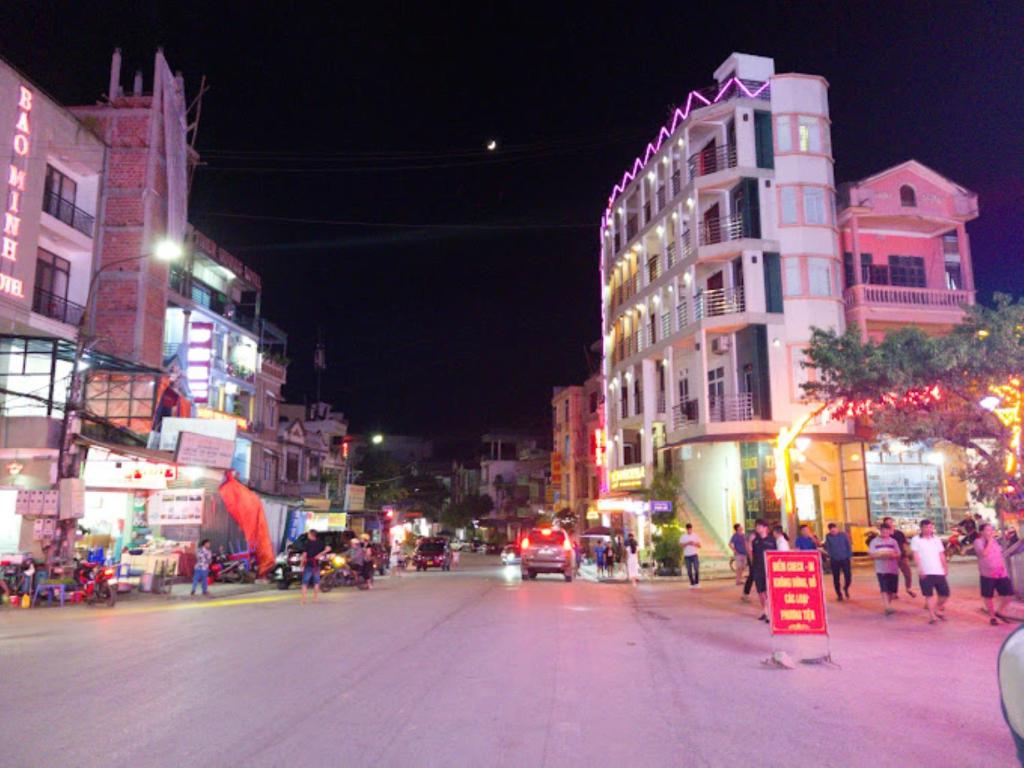 同文Thái Thịnh Hotel的一条繁忙的城市街道,晚上有人员和汽车