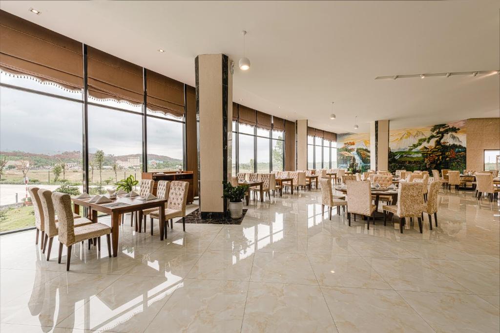 Kỳ Anh河静孟青大酒店的用餐室配有桌椅和大窗户