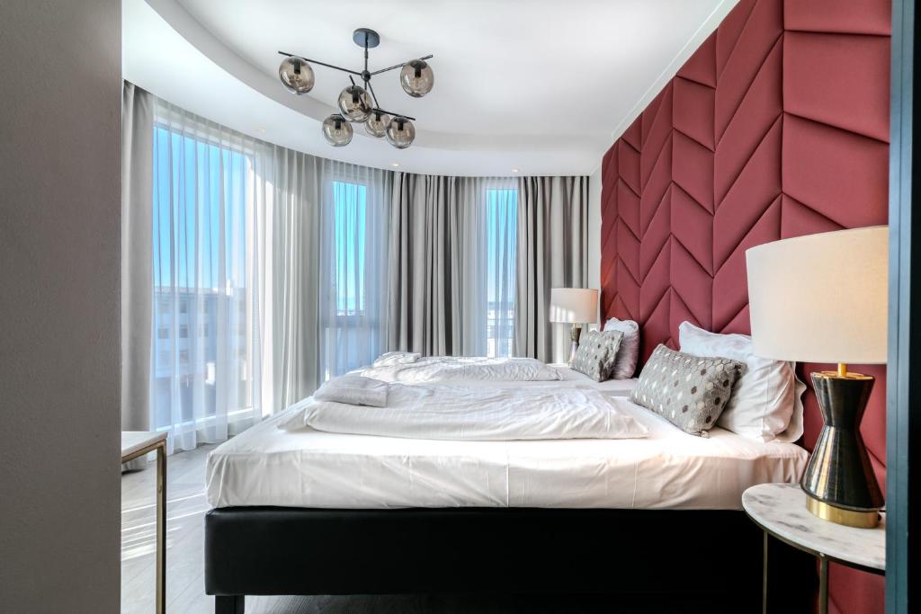 雷克雅未克Midtown Hotel的一间卧室配有一张大床和红色床头板