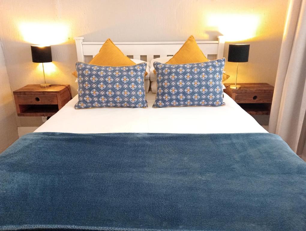 比勒陀利亚Willows Garden Studio的一间卧室配有蓝色和黄色枕头的床