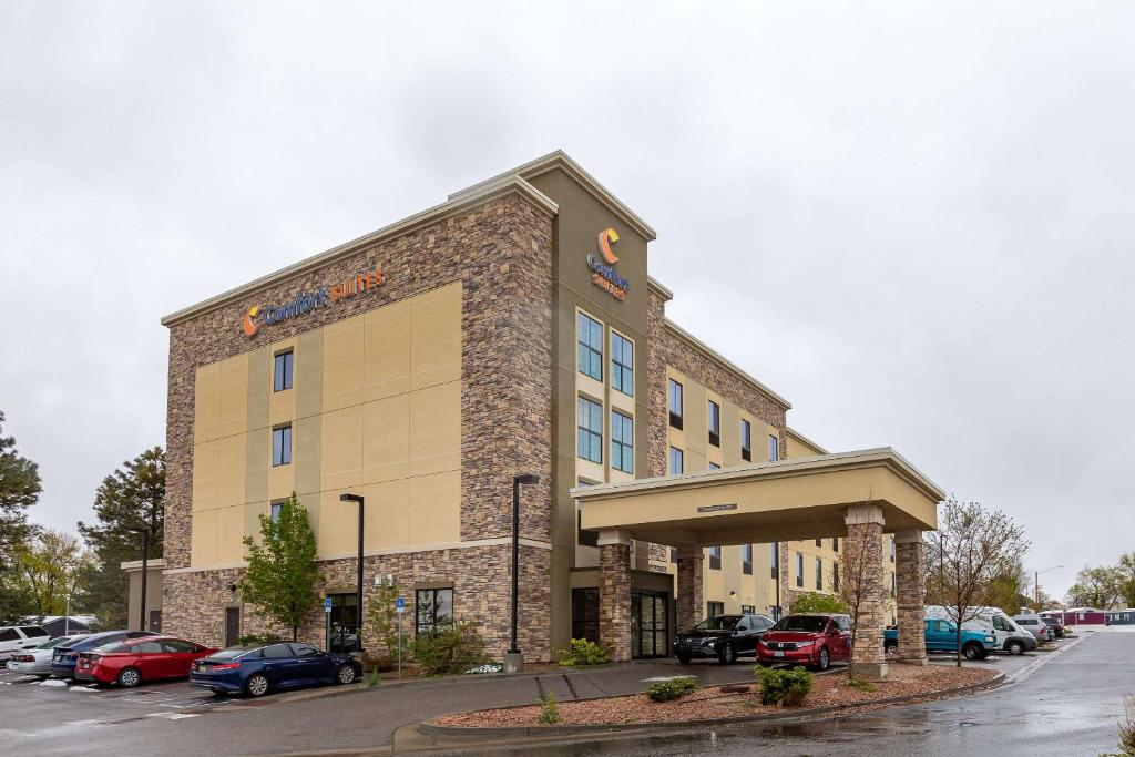 奥罗拉Comfort Suites Denver near Anschutz Medical Campus的停车场内有车辆的建筑物
