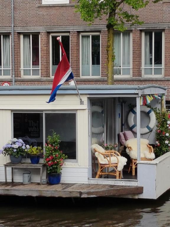 阿姆斯特丹顶楼船屋的船后方有旗帜的房子