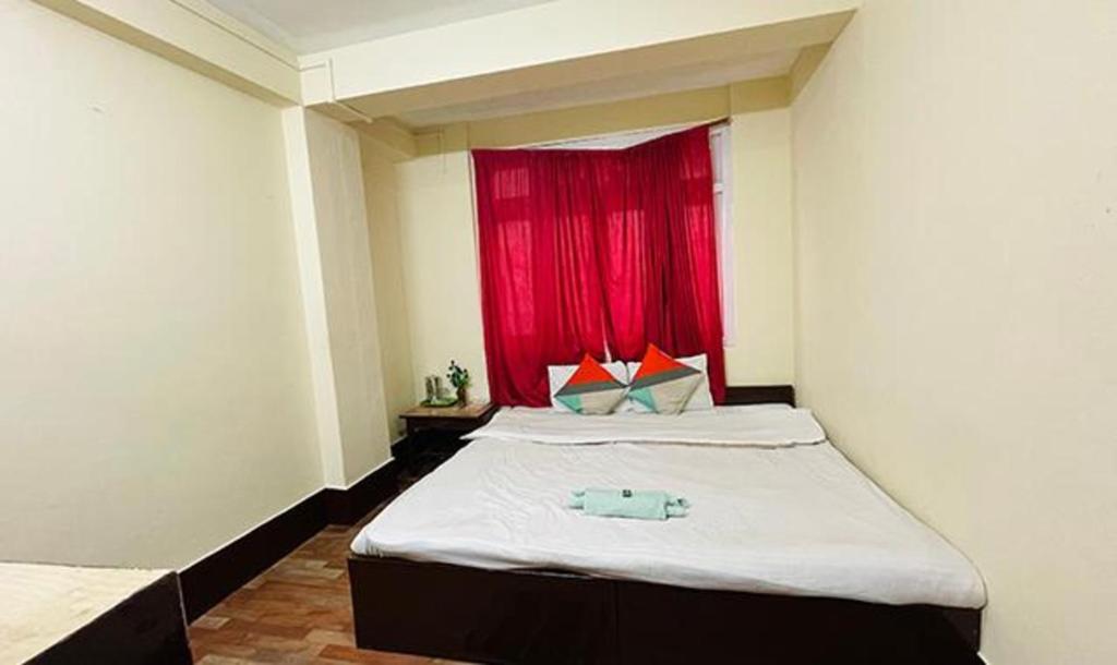 甘托克FabHotel Palbhu的一间卧室配有一张红色窗户的床