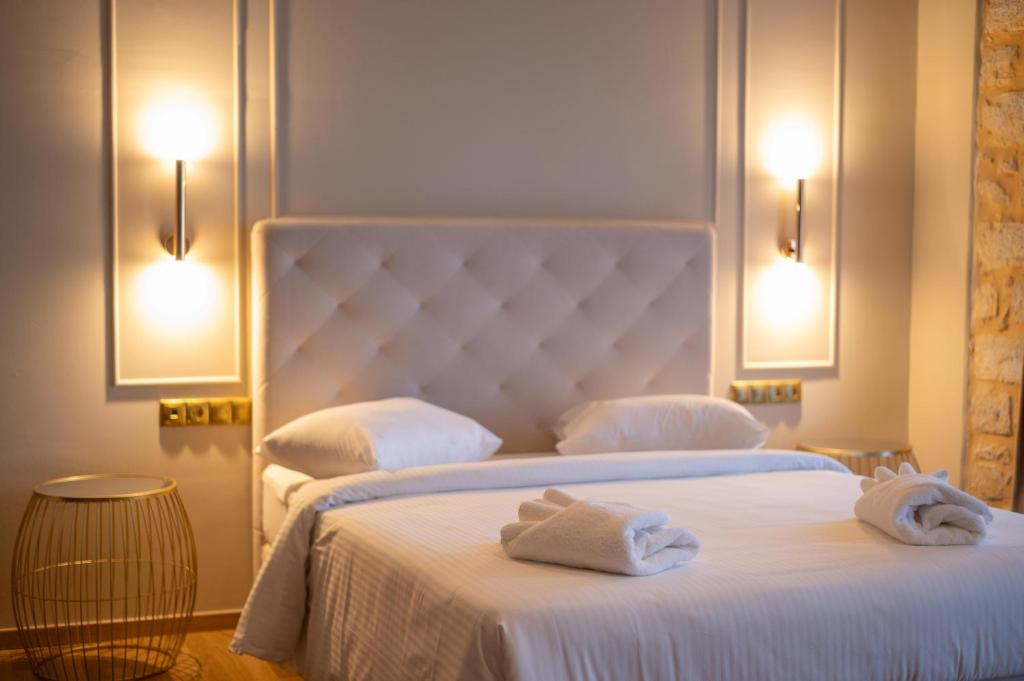伊西翁L Suites The Writer's House的两张位于酒店客房的床,配有毛巾