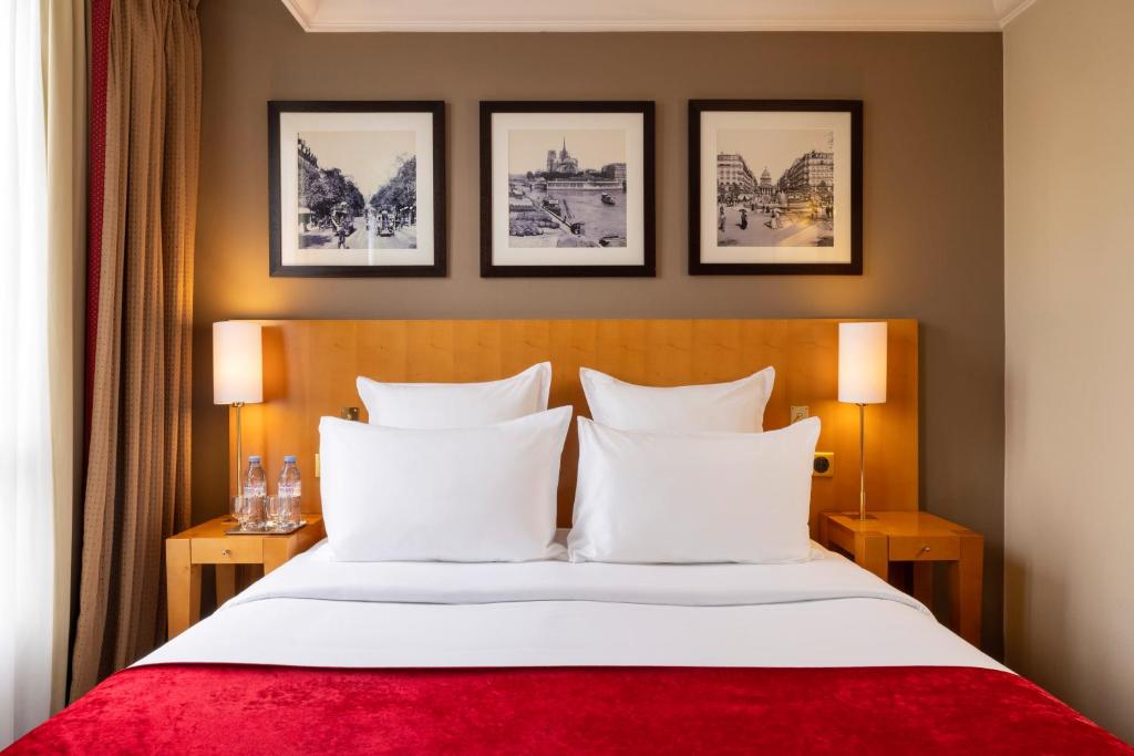 巴黎皇家圣米歇尔酒店的酒店客房,配有一张带红色毯子的床