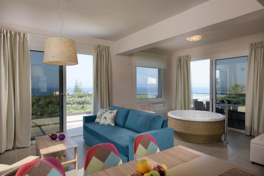 斯塔罗斯Koukos Villas的客厅配有蓝色的沙发和桌子