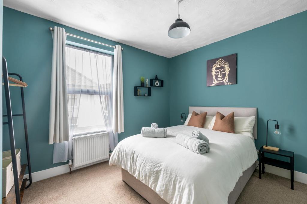 伊普斯威奇Shamrock House- 2 BR House, Free Parking & WIFI的卧室拥有蓝色的墙壁和一张床