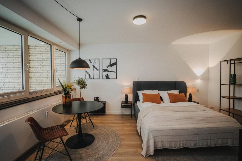 奥尔登堡DOWNTOWN Apartment mit Luxusbad am Hafen nur 5 Minuten zu Fuß in die Innenstadt!的卧室配有床、桌子和窗户。