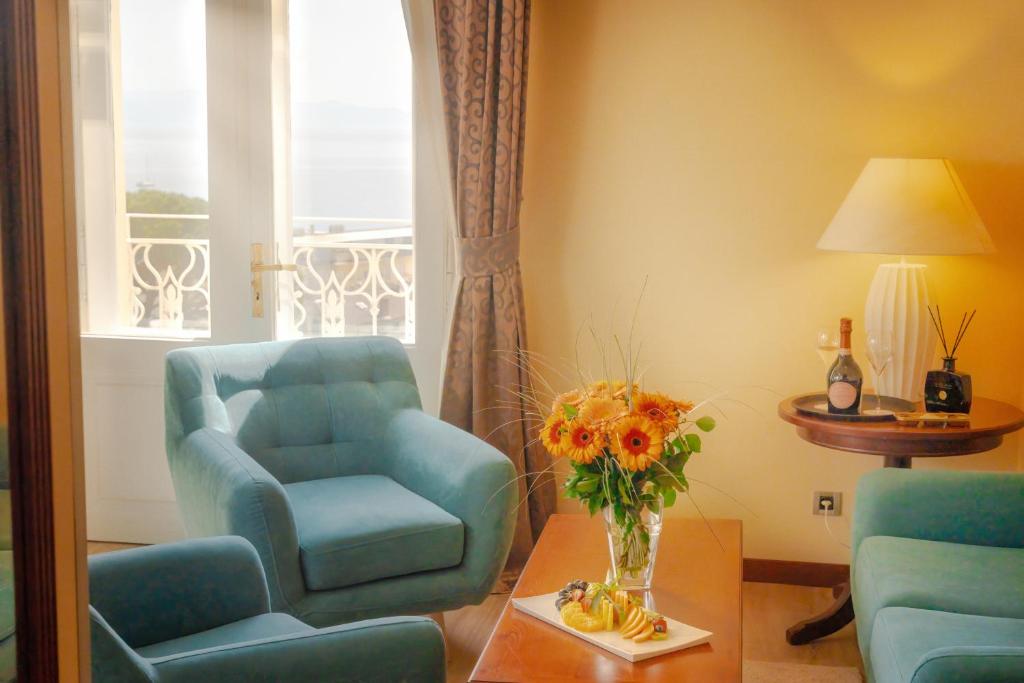 奥帕提亚BRISTOL Hotel Opatija的客厅配有椅子和花瓶