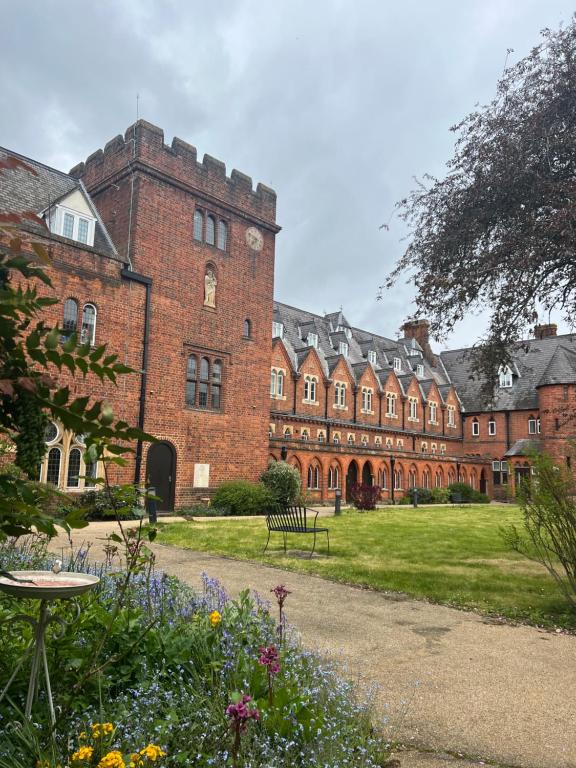 温莎Victorian convent的一座大型红砖建筑,前面有一个花园