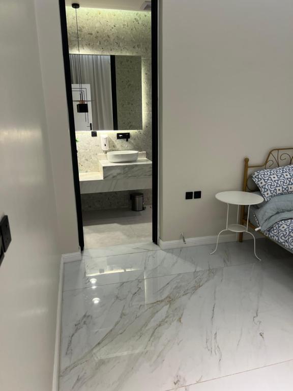 哈伊勒شاليه ضي的浴室铺有大理石地板,配有镜子