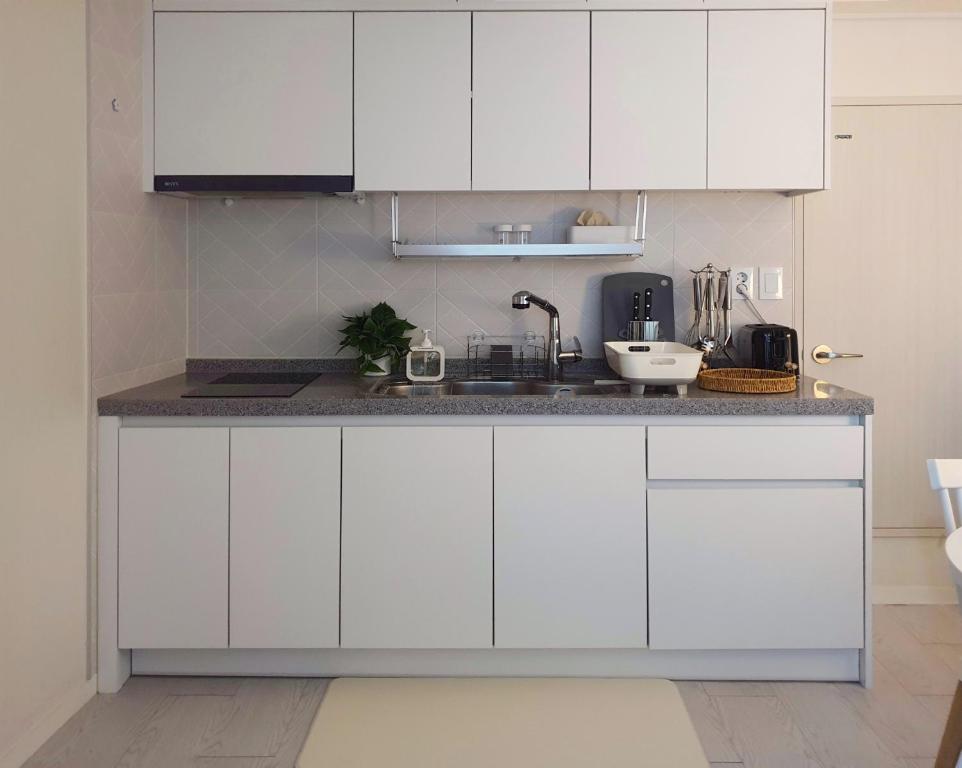 首尔Sunny House的厨房配有白色橱柜和台面