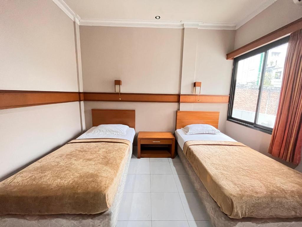 雅加达大篷车酒店的带2扇窗户的客房内的2张床