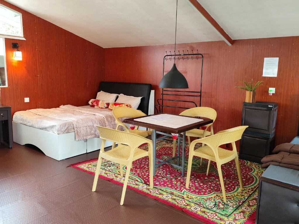 努沃勒埃利耶Townside Lodge的卧室配有一张床和一张桌子及椅子