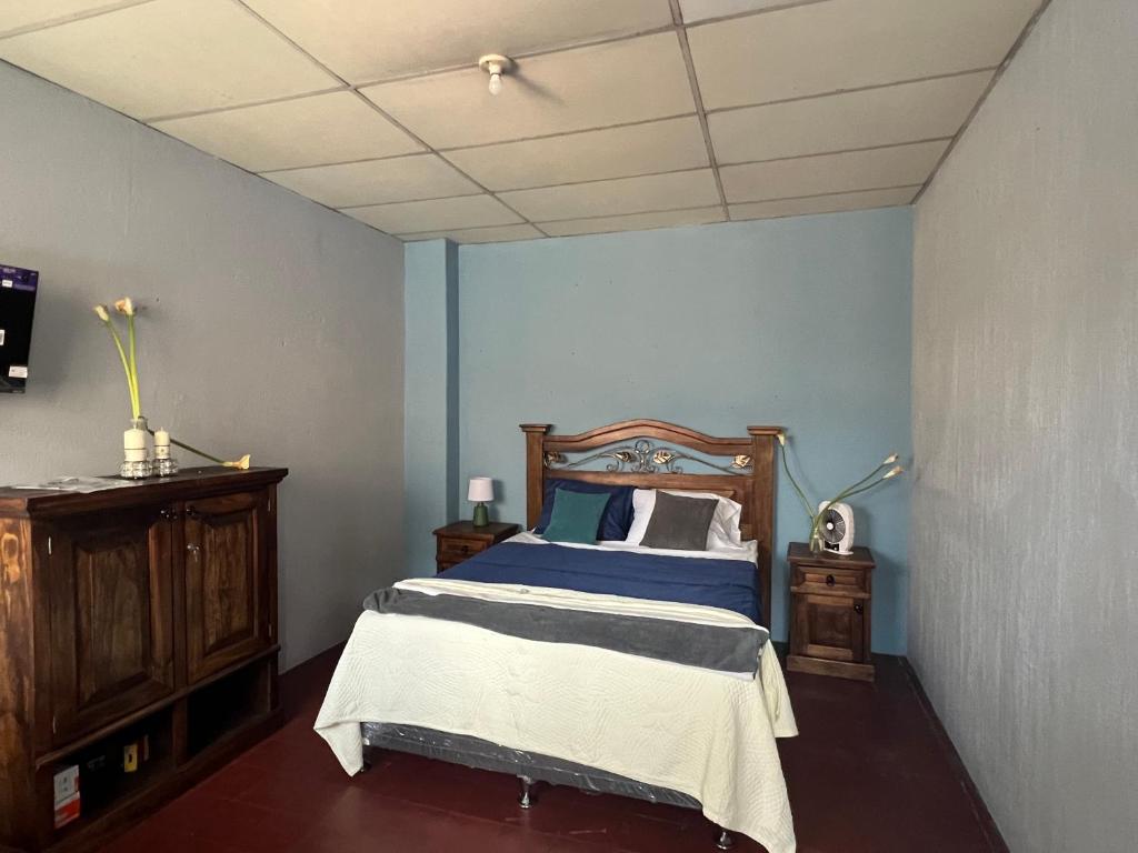 危地马拉Casa Bienestar的一间卧室配有一张蓝色墙壁的床
