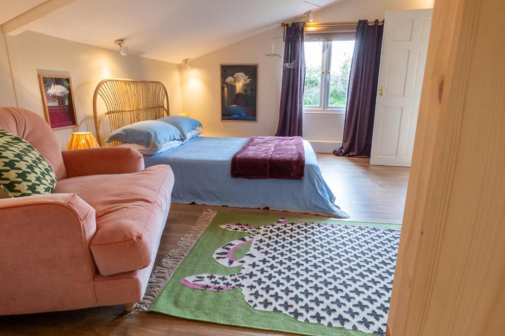 East StourThe Nook的一间卧室配有床、沙发和地毯。