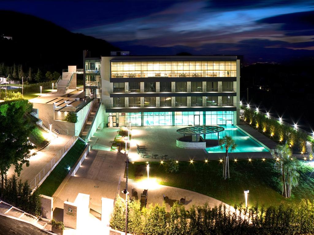 卡斯泰尔佩特罗索贝勒瑟尔酒店的一座建筑,在晚上前方有一个游泳池