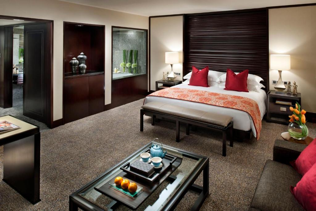 雅加达Mandarin Oriental, Jakarta的一间卧室配有一张带红色枕头的大床